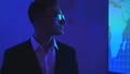 The man in glasses standing near a big screen 4k or 4k+ Resolution