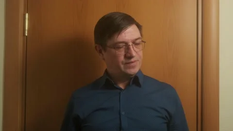The man with glasses stands in the background of the door and shakes his head Stock Footage 150694976