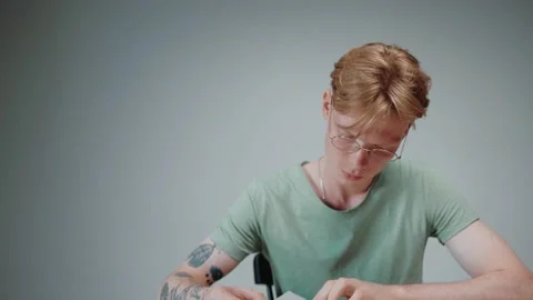 Man in glasses studying and stressing, reading a textbook in empty grey room Stock-Footage 164372022