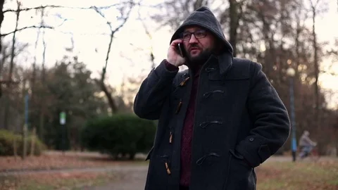 Man glasses talking on cellphone in the park autumn, Stock Footage 71023484