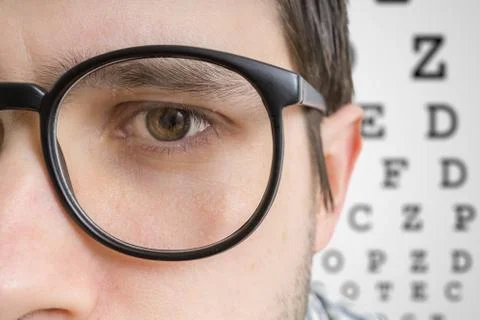Man with glasses is testing his sight. Closeup view on eye. Stock Photos