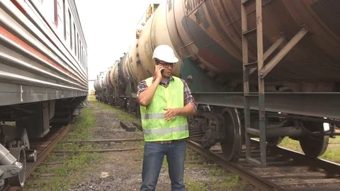 A man in glasses worker checking the train in a helmet and uniform, walking on Video stock 91305520