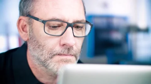 Man with glasses working on laptop computer Stock Footage