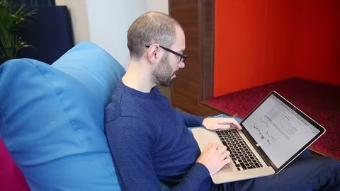 Man with glasses working on laptop Stock Footage 69976527