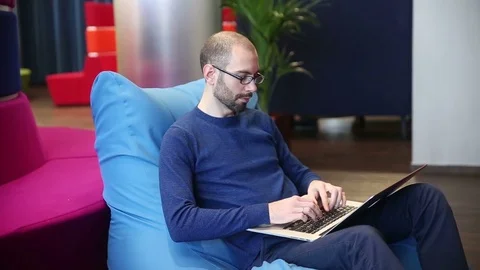 Man with glasses working on laptop Stock Footage 69977080