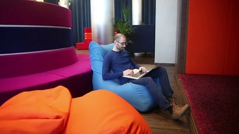 Man with glasses working on laptop Stock Footage 69977329