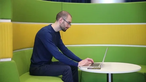 Man with glasses working on laptop Stock Footage 69977654