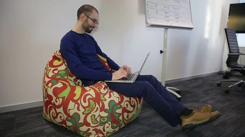Man with glasses working on laptop Stock Footage 69978509