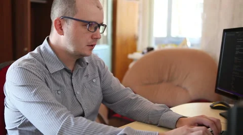 Man in glasses works behind a computer and laughing at a joke Stock-Footage 64830987