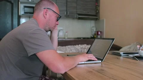 Man with glasses works at home in computer looking on monitor screen. Stock Footage 243583518