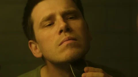 Man glides electric razor across face during morning routine Video stock 277969810