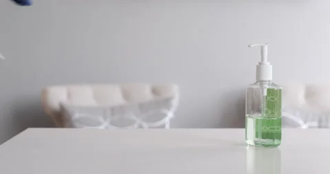 Man with gloved hands wiping down counter with hand sanitizer 動画素材 130671702