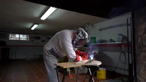 Man with gloves and mask welding a metal joint in his workshop. metal welding Stock Footage 146602453