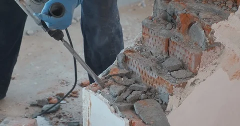 Man in gloves breaks brick wall in slow motion, vibration, wall trembles, dust Stock Footage 128637788
