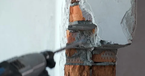 Man in gloves breaks brick wall in slow motion, builder breaks wall, destruction Stock Footage 128637869