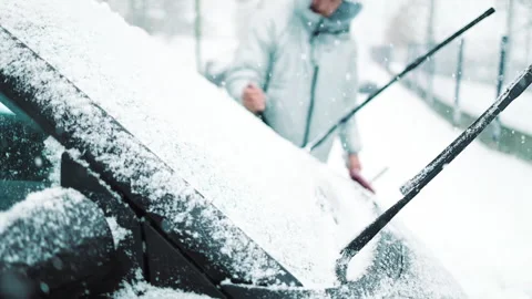 Man in gloves brushing deep snow from car windshield wiper blades Vidéo 341950769