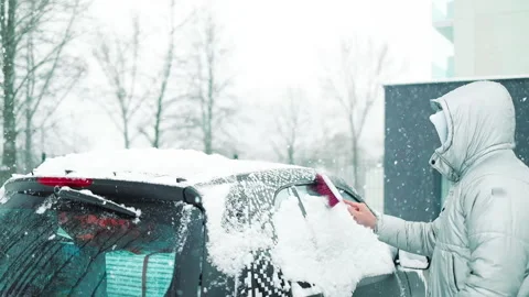 Man in gloves brushing deep snow from car windshield wiper blades Vidéo 341950885