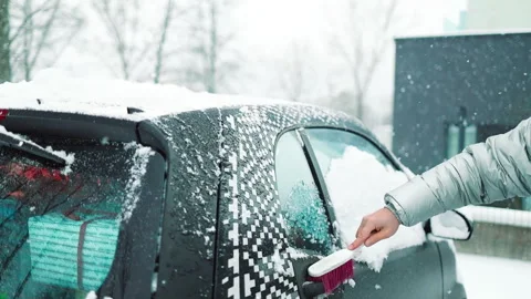 Man in gloves brushing deep snow from car windshield wiper blades Vidéo 341951301
