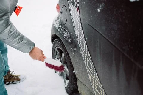 Man in gloves brushing deep snow from car windshield wiper blades Stock Photos