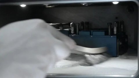 A man in gloves cleans the working chamber with a brush from a metal powder Stock Footage 91721696