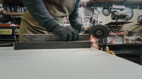 A man in gloves cuts metal with a circular saw, a lot of sparks. The working Stock Footage 142190955