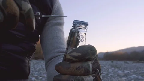A man in gloves opens a bottle of beer with a knife. Stock Footage 123211025