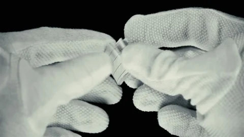 A man in gloves unfolds a note on a scrap of paper with the inscription: what Stock Footage 91204015