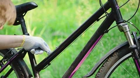 A man in gloves unscrews the bolts using a hex wrench on a mountain bike frame Stock Footage 133914805