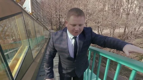 Man goes up to the bridge over the road. Stock Footage 80356060