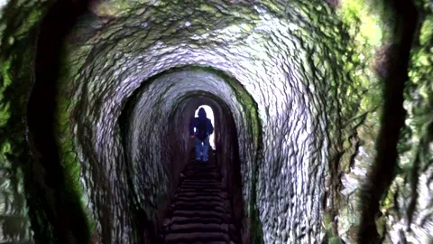 Man goes down the narrow old tunnel Stock Footage 131771284