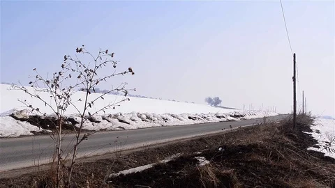 Man goes on a road from the fields intersect with a car that rushes in revers Stock Footage 91921505