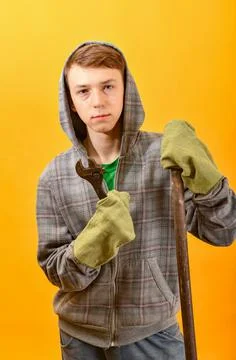 A man in goggles and gloves holds an adjustable wrench in his hands. Stock Photos