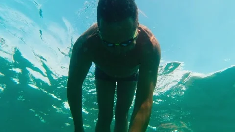 Man with goggles  dive into deep of the sea on sunny summer day Stock Footage 276693322