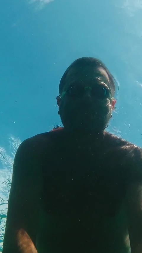 Man with goggles floating on the surface of the sea and filming himself fro.. Video stock 278516538