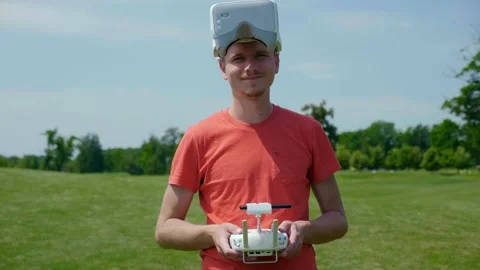 Man in goggles for a quadrocopter and with a remote control in hands and smiles Stock Footage 130488798