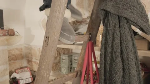 A man going up and down an old ladder at home (a tiny cozy one). Angled Stock Footage 253555741