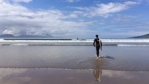 Man Going To The Beach Holding Surfboard on Sunny Summer Day, Dingle, Ireland Stock Footage 90819429