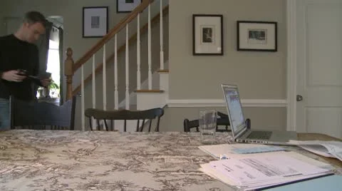 A man  going to dining room table to work on his finances (4 of 4) Stock Footage 10564986