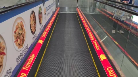 A man going down the elevator inside the modern airport Stockbeeldmateriaal 246430717