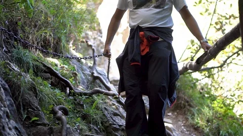 A Man Going Down A Narrow Trail In The Rocky Forest - Wide Shot Stockbeeldmateriaal 125780117