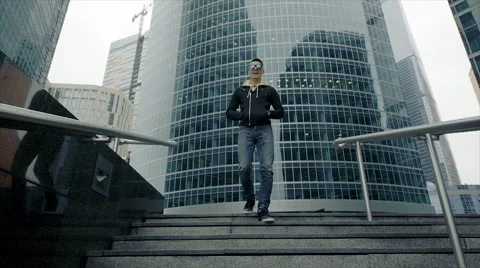 A man going down the stairs with a building in the background. Video stock 61799455