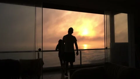 A man going to hug his partner on the terrace of a beach house with a beautiful Video stock 193077999