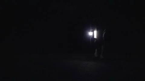 Man going with lamp on the empty night road Stock Footage 155979610