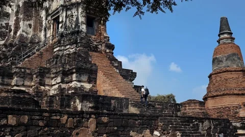 Man going up to an old buddhist temple Wat Mahathat - AYUTTHAYA Thailand Stock Footage 176157680