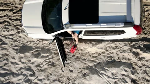 Man going out from the car in flippers at sandy beach Stock Footage 170462532