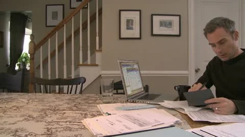 A man going over his bills on his dining room table (2 of 3) Stock Footage 10564900