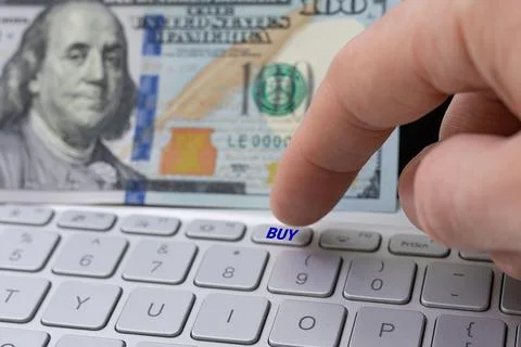 The man is going to press button "BUY" on the laptop Stock Photos