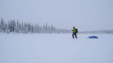 Man going with sled on snow in white winter landscape Stock Footage 98496726
