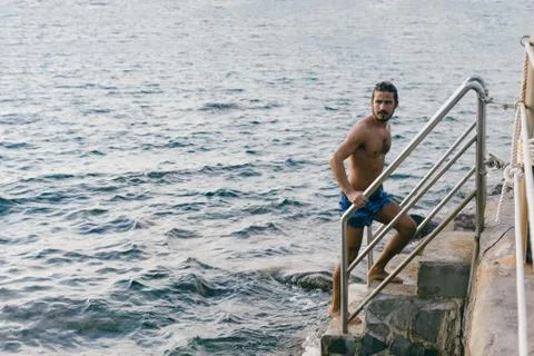 Man going up steps from sea Stock Photos