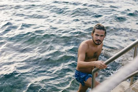 Man going up steps from sea Stock Photos
